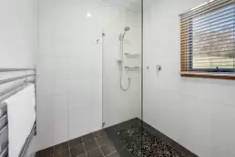 The main bathroom with a shower and towel ladder 215 Mt Buffalo Pool House. This is a family friendly and pet friendly accommodation option in Porepunkah.