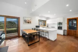 A photo of the kitchen and dining areas at 215 Mt Buffalo Pool House. This is a family friendly and pet friendly accommodation option in Porepunkah.