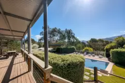 A photo showing the view from the deck down to the pool at 215 Mt Buffalo Pool House. A family friendly and pet friendly accommodation in Porepunkah.